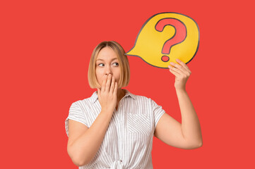 Shocked adult woman holding speech bubble with question mark on red background