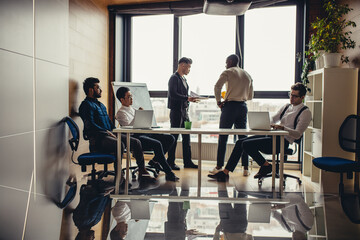 Panoramic picture of multiracial group of people meeting in modern spacious office interior with a panoramic window