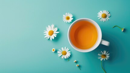 Chamomile herbal tea in a white cup on turquoise backdrop