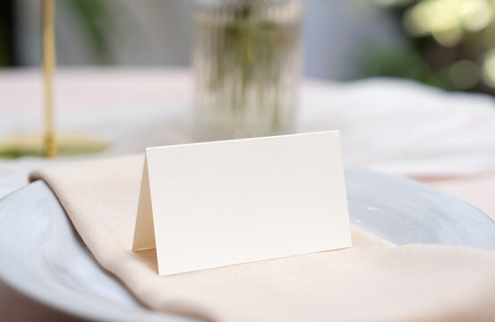 Mockup white blank space card, for Name place, Folded, greeting, invitation on wedding table setting background. with clipping path