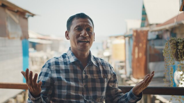 Portrait of the Indonesian man sitting outdoor with buildings on the background