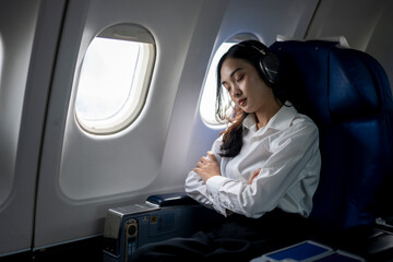 A woman is sleeping on an airplane