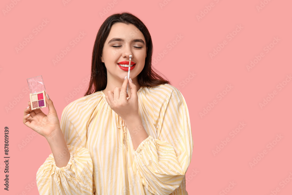 Sticker beautiful young woman with palette of eyeshadows and makeup brush on pink background