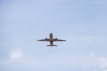 Airplane flying in blue sky, bottom view. Passenger plane at flight, travel concept