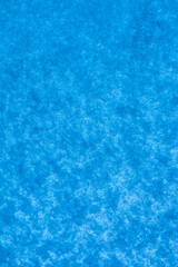 Snow texture on blue glass. Background textured snow on blue