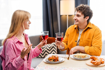 Couple enjoying delicious meal and wine celebrating special occasion, dinner concept, relationship