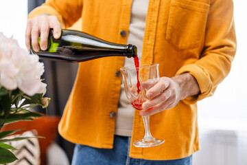 Man pouring red wine into glass in casual setting closeup