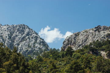 two mountains form a natural frame in the middle of which is a white cloud against the background of the blue sky