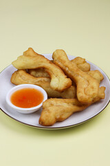 Cakwe or Youtio, popular Southeast and East Asian cuisine, made from Chinese dough and deep fry, savory taste served with chili sauce. Isolated background with copy space.