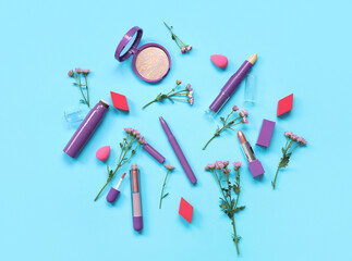 Beautiful composition with flowers, makeup sponges and decorative cosmetics on blue background