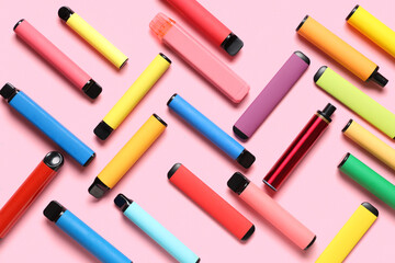 Different electronic cigarettes on pink background