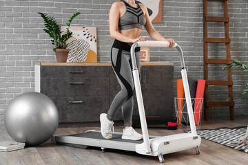 Sporty woman training on treadmill at home