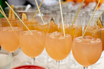 Chilled alcoholic cocktails served in rows on a buffet table in elegant glasses at a catered event