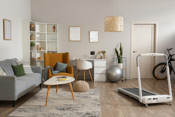 Interior of modern living room with sofa, armchair and treadmill