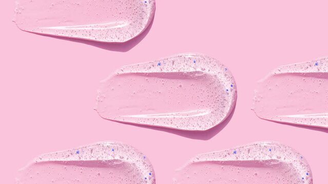 smears round drop of peeling gel test sample of scrub cosmetics on pink background