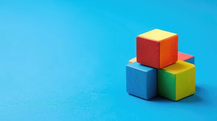 Obraz premium Colorful geometric cube toy on blue background with copy space Abstract pattern design by shape and form Educational innovative design concept