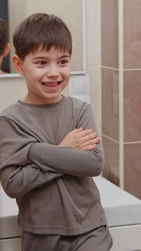 boy and baby child in bathroom,brushing teeth,washing hands with soap,combing hair.siblings,brothers in front of sink on tabouret chair.kids on toilet with lot of paper.