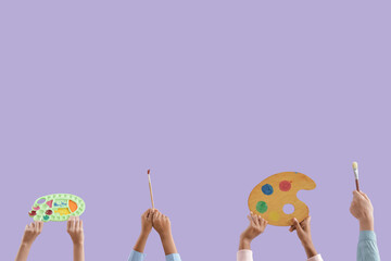 Children with paint palettes and brushes on lilac background