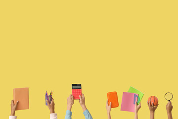 Children with school stationery on yellow background