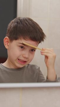 boy and baby child in bathroom,brushing teeth,washing hands with soap,combing hair.siblings,brothers in front of sink on tabouret chair.kids on toilet with lot of paper.