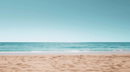 Obraz premium A serene beach with golden sand, calm turquoise waves, and a clear blue sky. Ideal scene for relaxation and tranquility