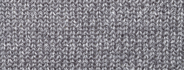 Fototapeta premium Texture of gray color background from woven knitted textile material with wicker pattern, macro.