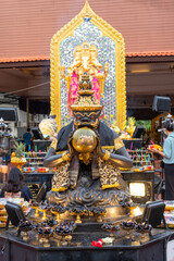 Statue of Rahu swallowing the moon, black and gold color, with Ganesha in the back, which is worshipped by many Buddhists and often visited to pay homage at Bang Yai Temple, Nonthaburi, Thailand.