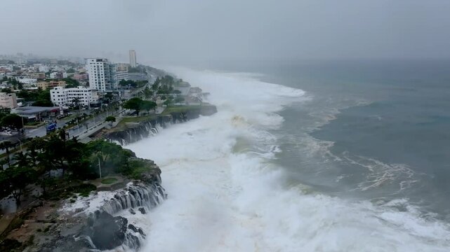 Aerial view of giant cyclone waves crashing and flooding the seafront of the city