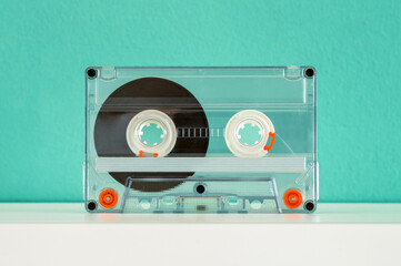 Old school audio cassette tape rests on a white shelf