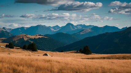 Fototapeta premium Scenic Sunny Mountain Range with Golden Grass Under Blue Sky