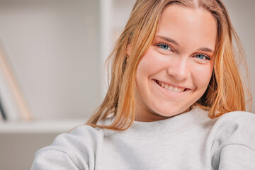 portrait of blue eyed blonde young woman or student at home