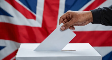 UK elections. British democracy in action with voter participating in election, hand casting ballot at polling station against UK flag backdrop, national decision making process