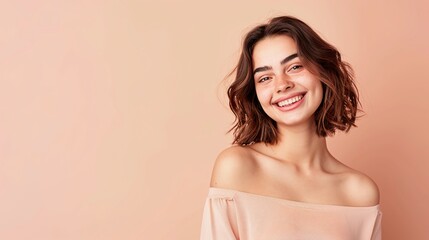 Fototapeta premium Joyous young woman with beaming smile and soft peach backdrop