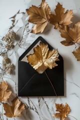 Fototapeta premium A black envelope with a gold leaf motif, ideal for use in designs about luxury, elegance and sophistication