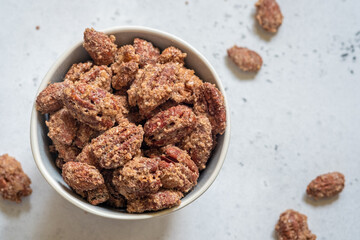 A bowl of nuts is sitting on a white table