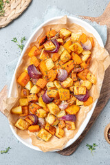 A white plate of vegetables with onions and herbs on top