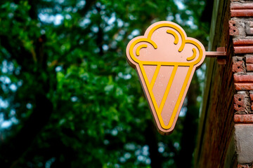 ice cream shop sign on a brick wall.