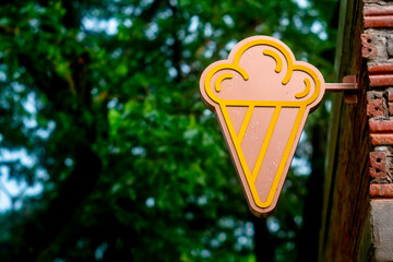 ice cream shop sign on a brick wall.