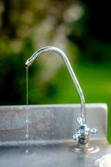 stainless steel faucet with green background