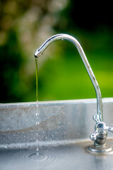 stainless steel faucet with green background