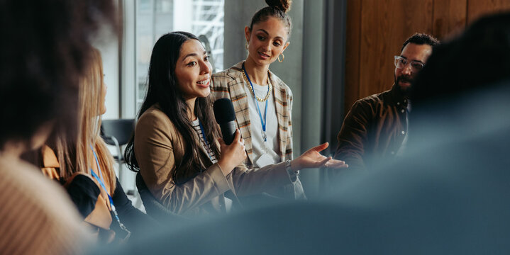 Woman talking and engaging in a debate with peers during a group meeting