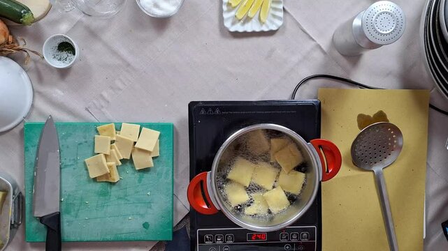 Panelle or Panella chickpea fritters fried in pot with oil as chef checks temperature infrared sensor