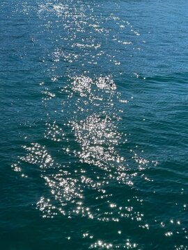 Blue sea water with glittering sun glare on surface