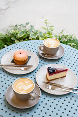 Two cups of cappuccino with desserts on the table in a sidewalk cafe.