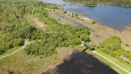 Aerial view showcasing the lush greenery and serene waters of Derryounce Lakes and Trails in Portarlington, County Laois. Captured in June, the footage highlights the natural beauty of the landscape.
