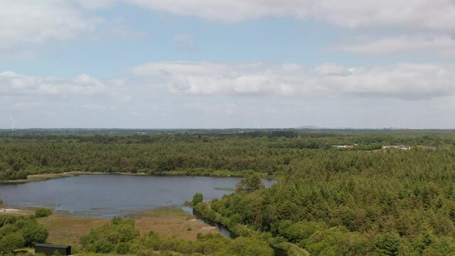 Aerial view of Derryounce Lakes and Trails in Portarlington, County Laois, captured in June. The footage showcases a tranquil landscape with lush greenery and a scenic lake.