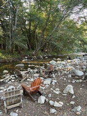 Deck chairs alongside river and woods in Big Sur, California