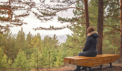 A Person Relaxing on a Bench in a Peaceful Forest Setting During the Autumn Season