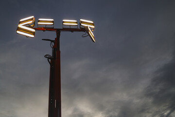 Mobile LED (light-emitting diode) light tower, against an ominous semi-dark sky. Moved, placed in...