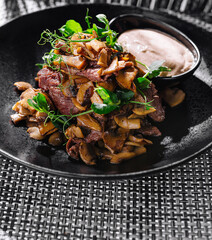 Gourmet fried mushrooms with beef steak and dip on elegant plate